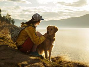 luxury real estate agenda: women sitting with dog on top of hike