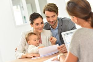 couple with child sitting down with real estate agent